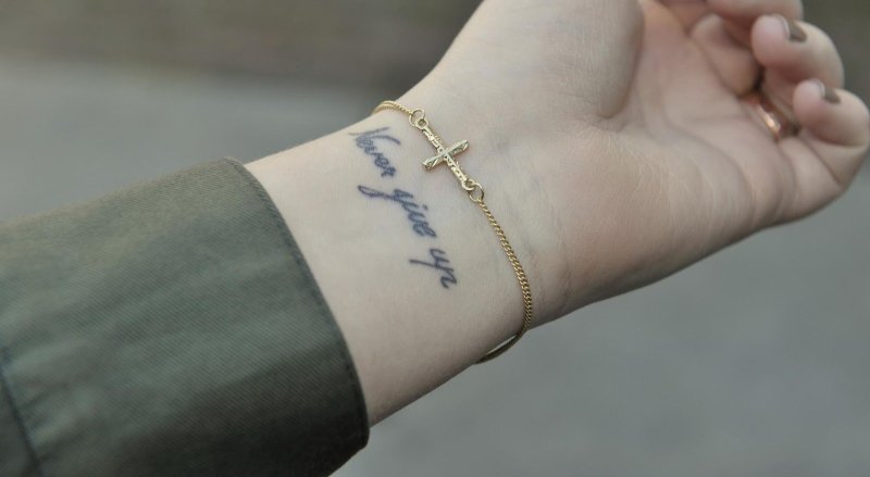Тату never give up на руке